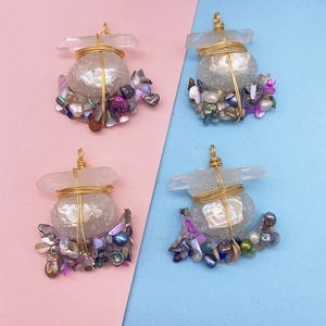 Detail of handmade bohemian pendant with wire-wrapped raw stones, shells and pearls