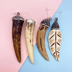 Detailed view of chili and leaf resin charms with rhino horn texture and rhinestone caps