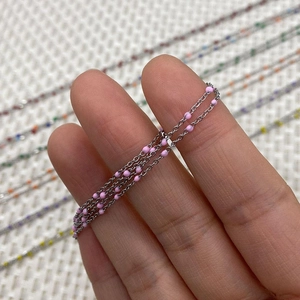 Dettaglio di catena in acciaio inossidabile argento con perline smaltate rosa per gioielli