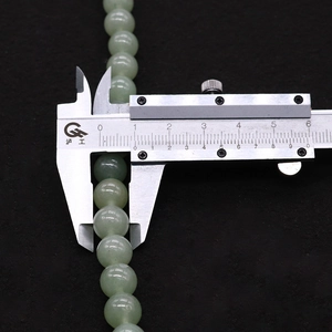 Measuring 8mm natural green aventurine round beads with a caliper for DIY jewelry making
