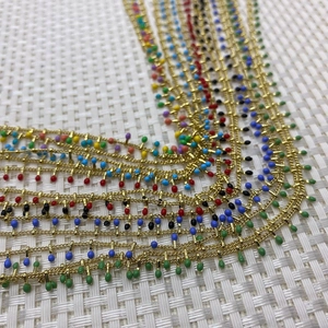 Macro detail of colorful enamel bead charms on a gold-plated DIY jewelry making chain