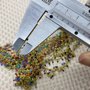 Macro shot showing measurement of 3mm colorful enamel beads on a gold chain