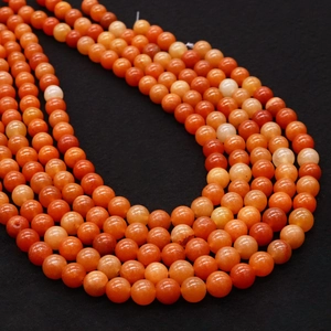 Orange aventurine natural stone round beads for jewelry making, stacked on black background