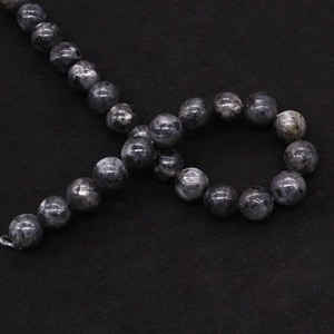 Dettaglio macro di perle di labradorite grigio scuro lucido con trama naturale e lucentezza