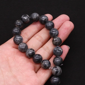 Dettaglio di perle in pietra naturale grigio scuro da 12 mm con trama minerale