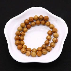 Macro de perles en pierre naturelle de bois poli présentées sur une assiette blanche en pétale