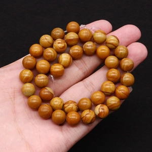 Gros plan de perles en pierre de bois naturel avec texture brune pour bijoux DIY