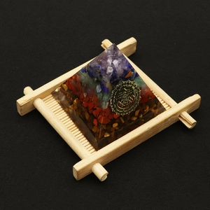 Orgone Energy Pyramid with colorful natural stones and golden Sri Yantra geometry symbol