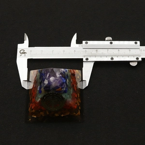 Macro detail of a 5cm Orgone Energy Pyramid showing layered natural healing crystals