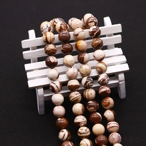 Macro detail of polished brown Australian Zebra Jasper beads with natural marble texture