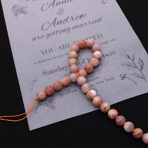 Macro shot of polished orange sunstone beads showing natural mineral shimmer for DIY jewelry