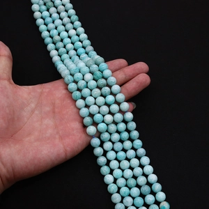 Macro shot of polished light blue amazonite gemstone beads with natural white textures
