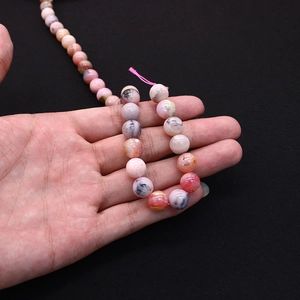 Macro detail of natural stone beads with pink marble texture for DIY jewelry making
