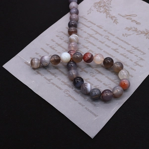 Macro shot of polished Persian agate beads showing natural banded textures for jewelry DIY