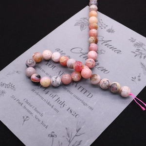 Macro detail of natural pink stone round beads with unique polished textures for DIY jewelry