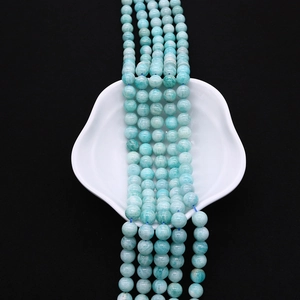 Close-up of polished light blue amazonite round beads showing natural stone texture