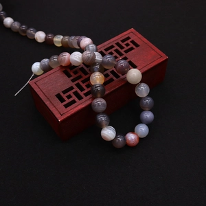 Macro detail of natural Persian agate beads with silk texture on vintage wood