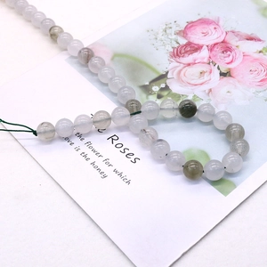Detalle macro de cuentas redondas de piedra natural traslúcida con inclusiones para joyería DIY
