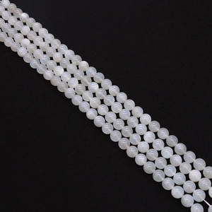 Dettaglio macro di perle di pietra di luna bianca con traslucenza naturale e finitura