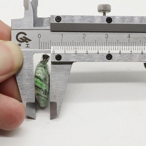 Detaillierte Messung des runden grün-schwarzen Steinanhängers mit einem Durchmesser von 8,8 mm