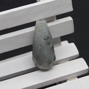 Macro view of water drop faceted white turquoise stone pendant with natural texture