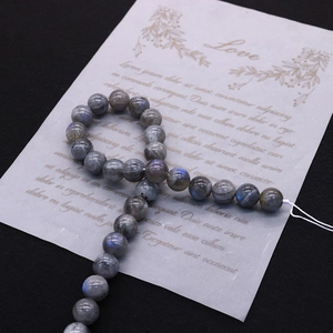 Close-up of natural labradorite stone beads with blue flash on black background