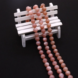 Macro detail of natural peach sunstone beads showing smooth polished texture and shimmer
