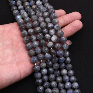 Natural labradorite round beads with blue flash held in hand for jewelry making