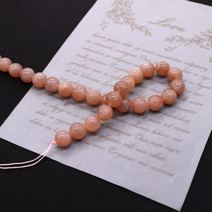 Macro detail of natural light orange sunstone beads with shimmering gold glitter surface