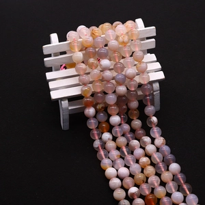 Macro detail of natural cherry blossom agate round beads with smooth polished texture