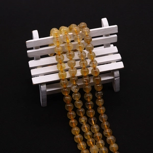 Macro view of polished yellow quartz crystal beads showing natural fibrous textures
