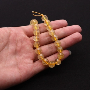 Macro shot of natural yellow crystal round beads bracelet with internal ice crack texture