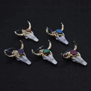 Vue macro de cinq pendentifs tête de buffle en résine avec incrustations de pierres naturelles