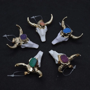 Détail de pendentifs tête de taureau en cristal avec touches dorées et pierres druzy