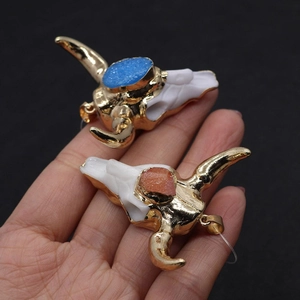 Détails macro de pendentifs crâne de taureau en résine avec cornes dorées et cristaux