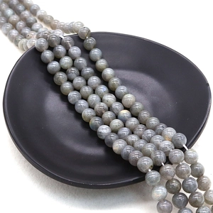 Polished grey labradorite round beads with blue and gold flash on black tray