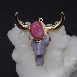 Pendentif tête de taureau avec cristal rose et cornes dorées sur minéral blanc