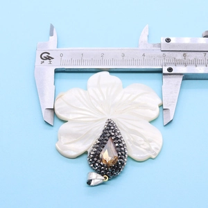 Detail van bloemvormige schelphanger met bruine druppelsteen en micro-pave zetting