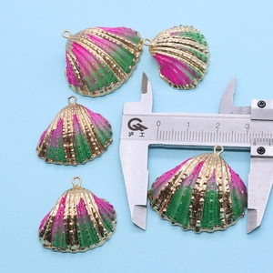 Vue détaillée de pendentifs coquilles Saint-Jacques dorés de 30 mm avec émail rose