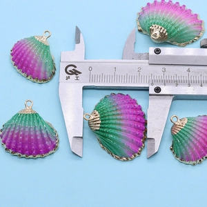 Vue détaillée d'un pendentif coquille violet avec bordure dorée et règle de mesure
