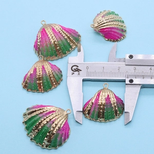 Mesure de la largeur d'un pendentif en forme de coquille avec un pied à coulisse de précision