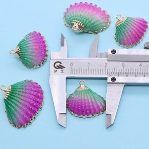 Vue macro mesurant un pendentif coquillage dégradé violet de 25 mm avec bords dorés