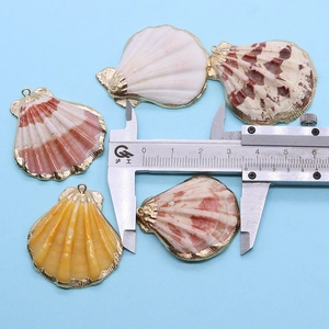 Vue détaillée d'un pendentif en coquillage naturel mesuré avec un pied à coulisse
