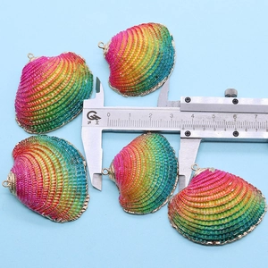 Rainbow dyed shell pendants with gold plated edges shown measured by a caliper