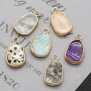 Detail of six irregular gemstone pendants with gold-plated edges and metal loops