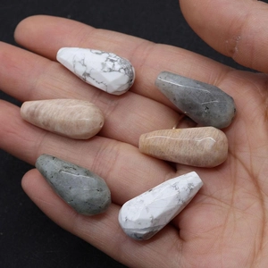 Macro shot of 12x25mm faceted teardrop natural stones in white, orange and grey colors