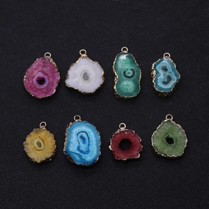 Detailed macro view of assorted natural stone crystal pendants with gold plated edges