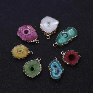 Detailed view of colorful raw crystal geode pendants with irregular gold plated edges