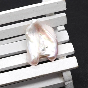 Primer plano de perla barroca natural con brillo nacarado en un soporte decorativo