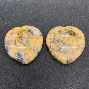 Détail macro de deux pierres naturelles polies en forme de cœur avec textures jaunes